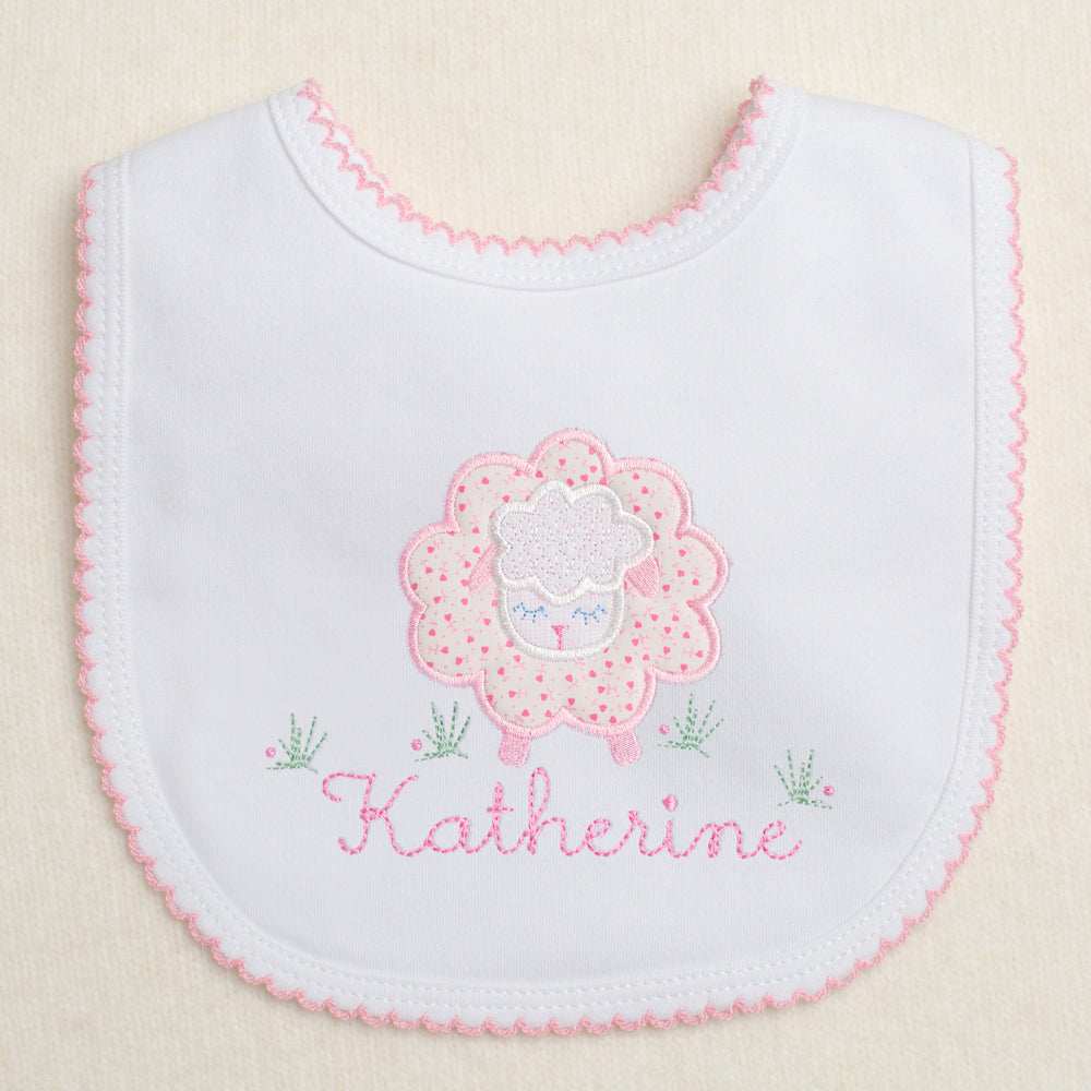 charming hand made appliqued bib with a pink floral sheep with a personalized name embroidered amongst the flowers