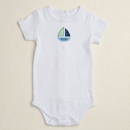 All cotton bodysuit with short sleeves and a blue sailboat applique that can be personalized with embroidery