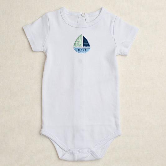 All cotton bodysuit with short sleeves and a blue sailboat applique that can be personalized with embroidery