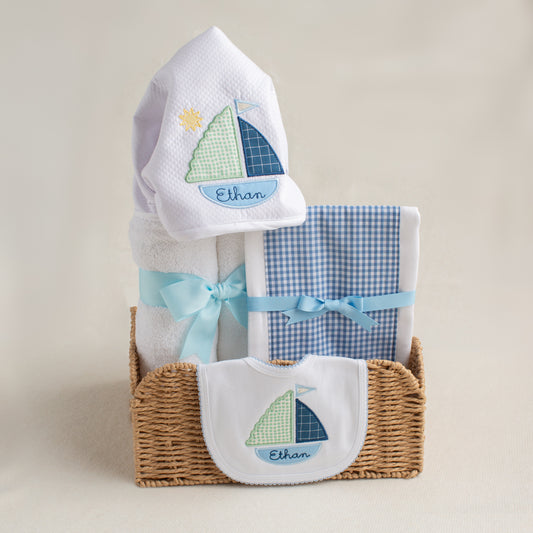 Charming 3 piece gift set for boutique gift giving.  Set includes a towel, fabric burp pad, and a bib.  The towel and the bib feature our handmade appliqued sailboat design with the baby's name cleverly embroidered inside the bottom of the boat.