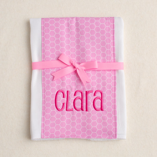 Boutique baby burp pad with pink hex fabric panel sewn down the center.  Personalized with embroidery and packaged tied with a grosgrain bow.