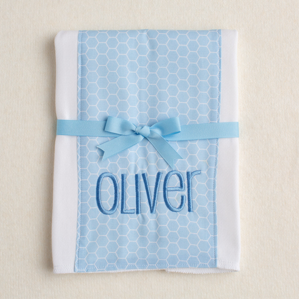 Boutique baby burp pad with blue hex fabric panel sewn down the center.  Personalized with embroidery and packaged tied with a grosgrain bow.