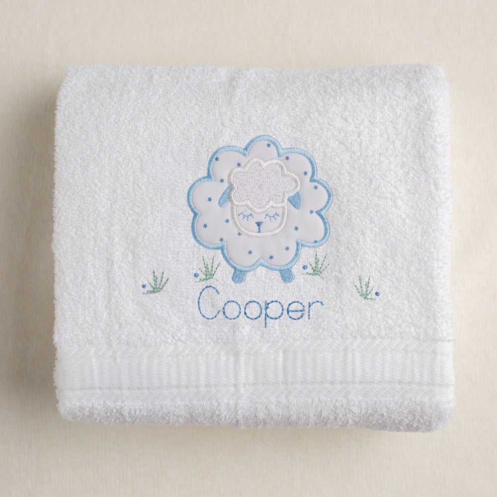 White bath towel with Deacon Lane's exclusive Blue Fluffy Sheep applique using a fabric with blue stars.  Hand made.