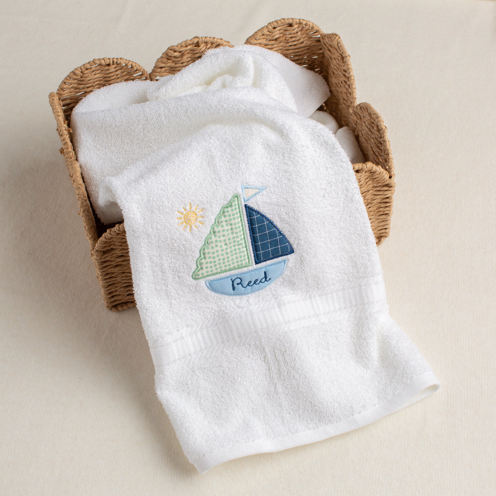 All white bath towel with Deacon Lane's exclusive sailboat applique with a custom personalization of the child's name inside the bottom of the boat.