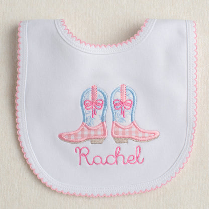 White bib with pink picot trim with appliqued pink and blue cowboy boots ready for easy gift giving