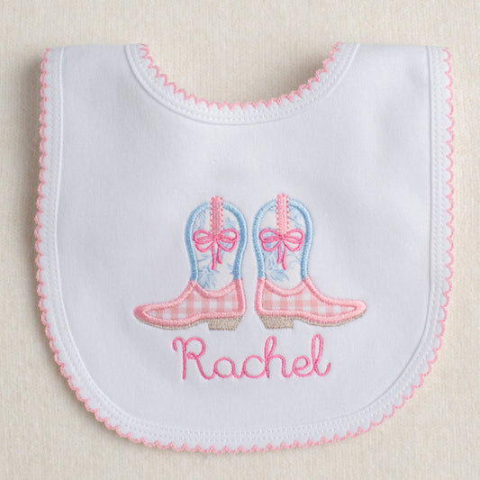 White bib with pink picot trim with appliqued pink and blue cowboy boots ready for easy gift giving