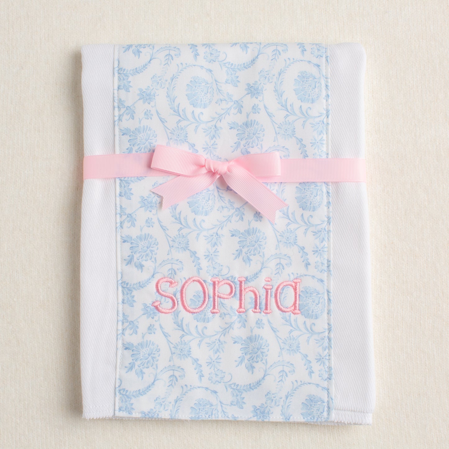 Floral-patterned burp pad personalized with an embroidered name perfect for one of a kind gift giving.