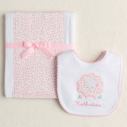 Exclusive Deacon Lane 2 piece gift set with appliqued bib and fabric burp pad with a pink floral sheep motif.