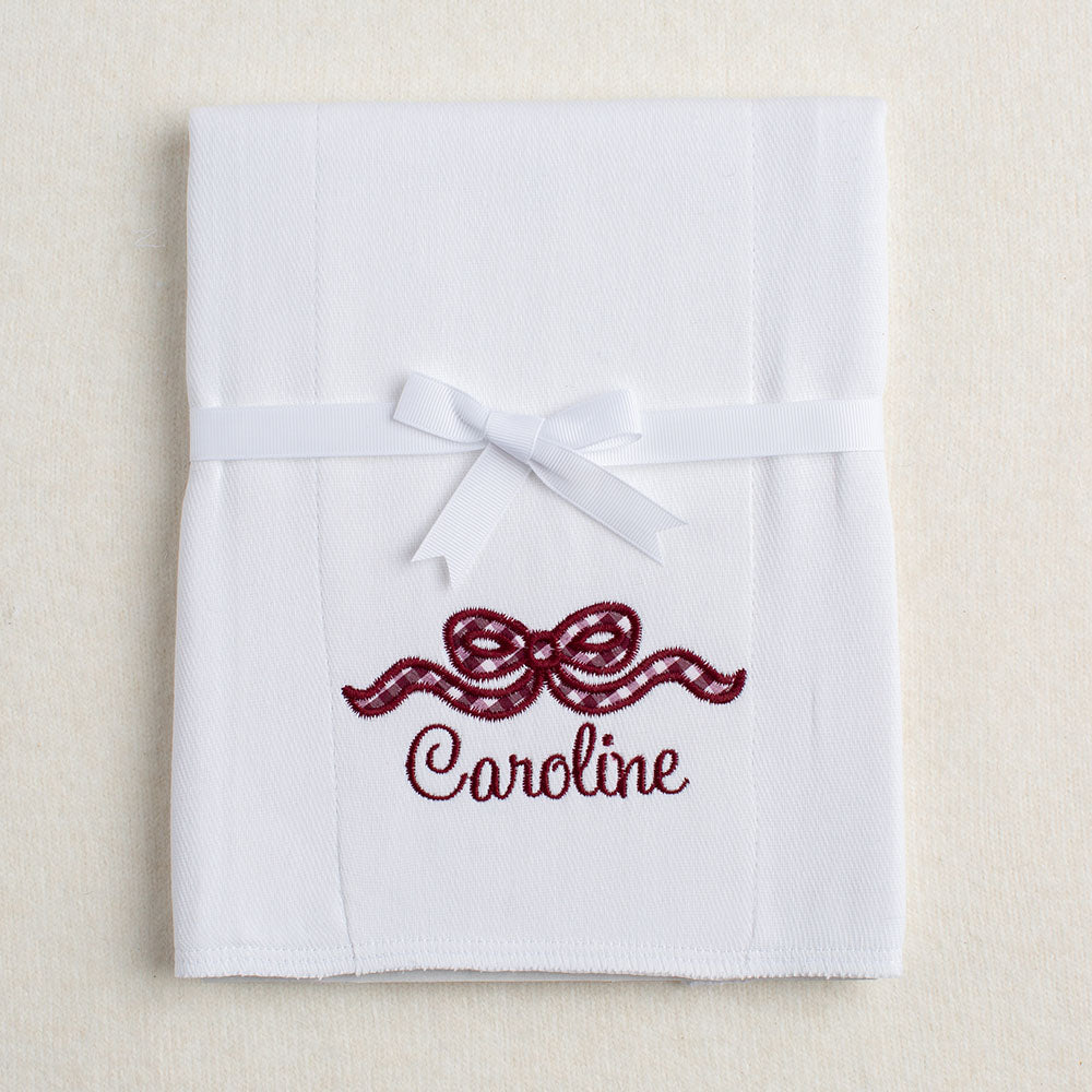 white burp pad with a maroon appiqued bow with a personalized, embroidered name in Texas A + M colors
