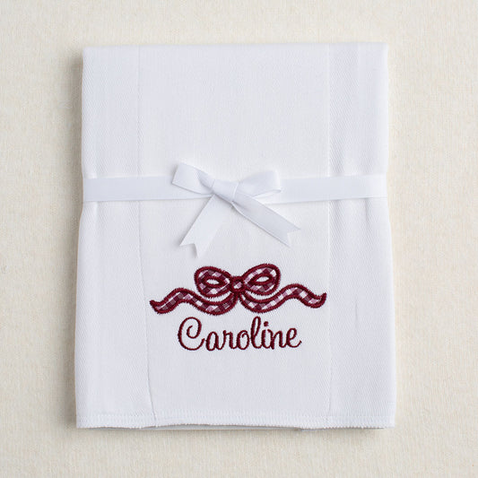 white burp pad with a maroon appiqued bow with a personalized, embroidered name in Texas A + M colors