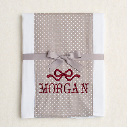 Cotton burp cloth with grey polka dots and a maroon embroidered name and special bow for Texas A + M fans