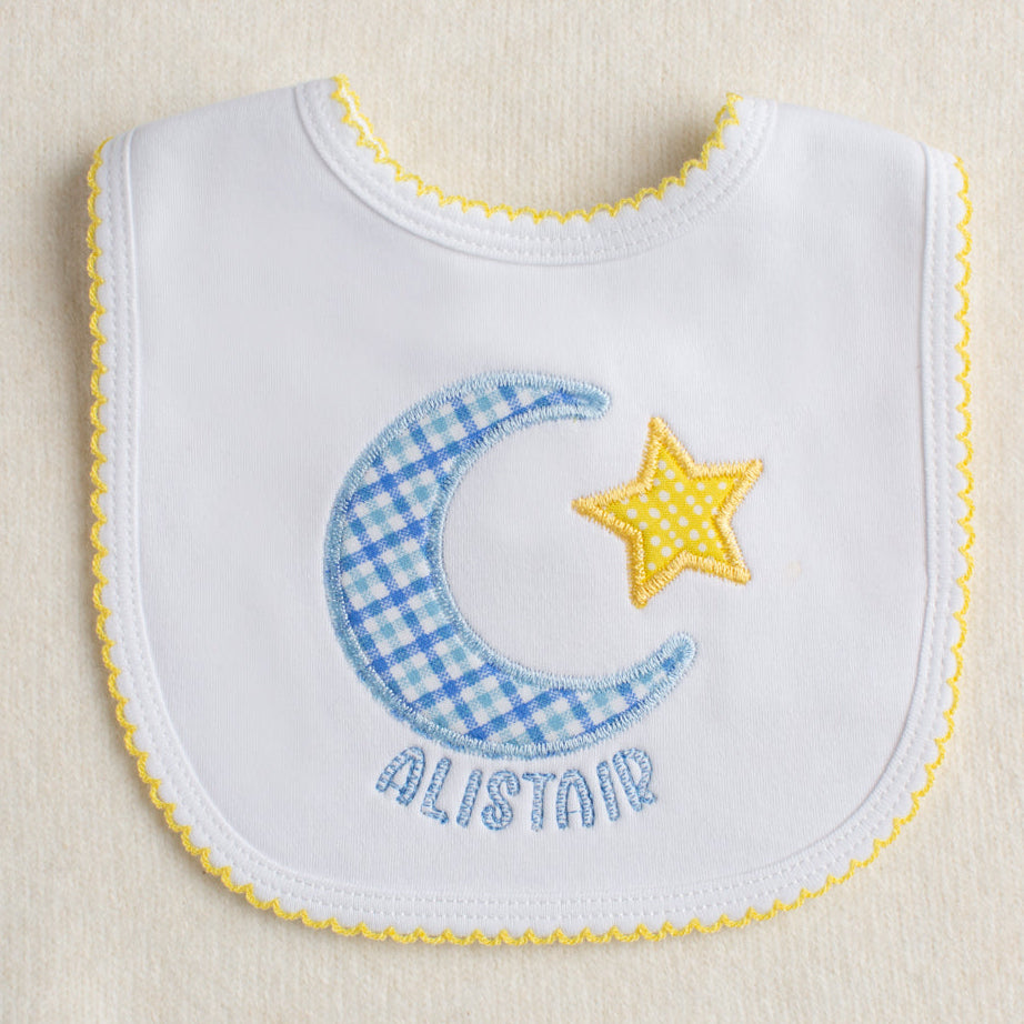 Baby boutique white knit cotton bib with picot trim and a hand made applique in a moon and star motif with a personalized name.