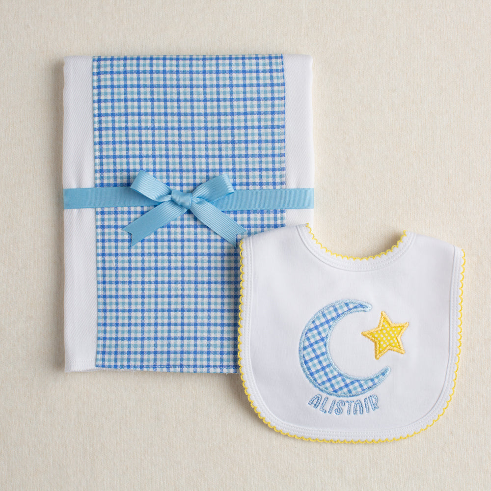 Personalized boutique baby gift set with a fabric burp pad made from an all cotton diaper and a hand appliqued bib with a moon and star motif personalized with a custom name.