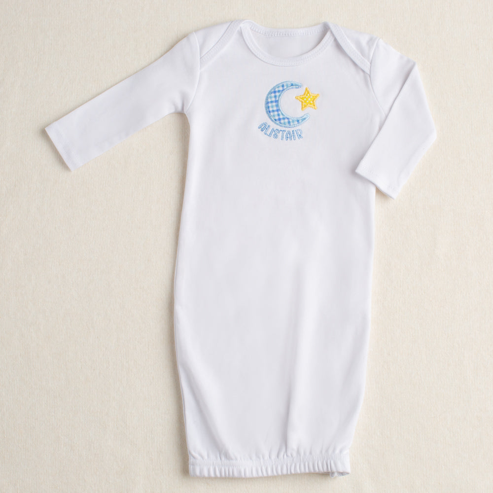 White baby gown with a zipper closure at the bottom and a hand applique moon and star motif and a personalized name
