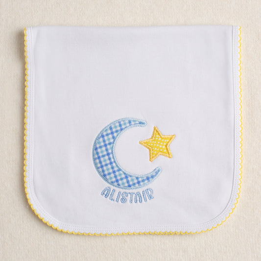 Yellow picot trimmed burp pad with moon and star applique with name embroidered circling the moon.