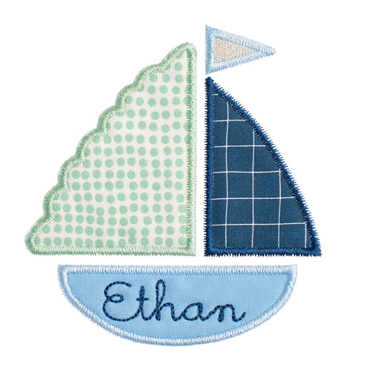 Close up of Deacon Lane's boy sailboat applique with child's name embroidered in the hull of the ship