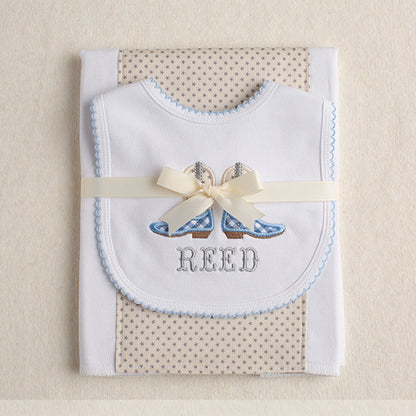 Boutique baby gift set with a fabric burp pad and an appliqued picot trimmed bib with cowboy boot appliques in light blue, grey and cream.