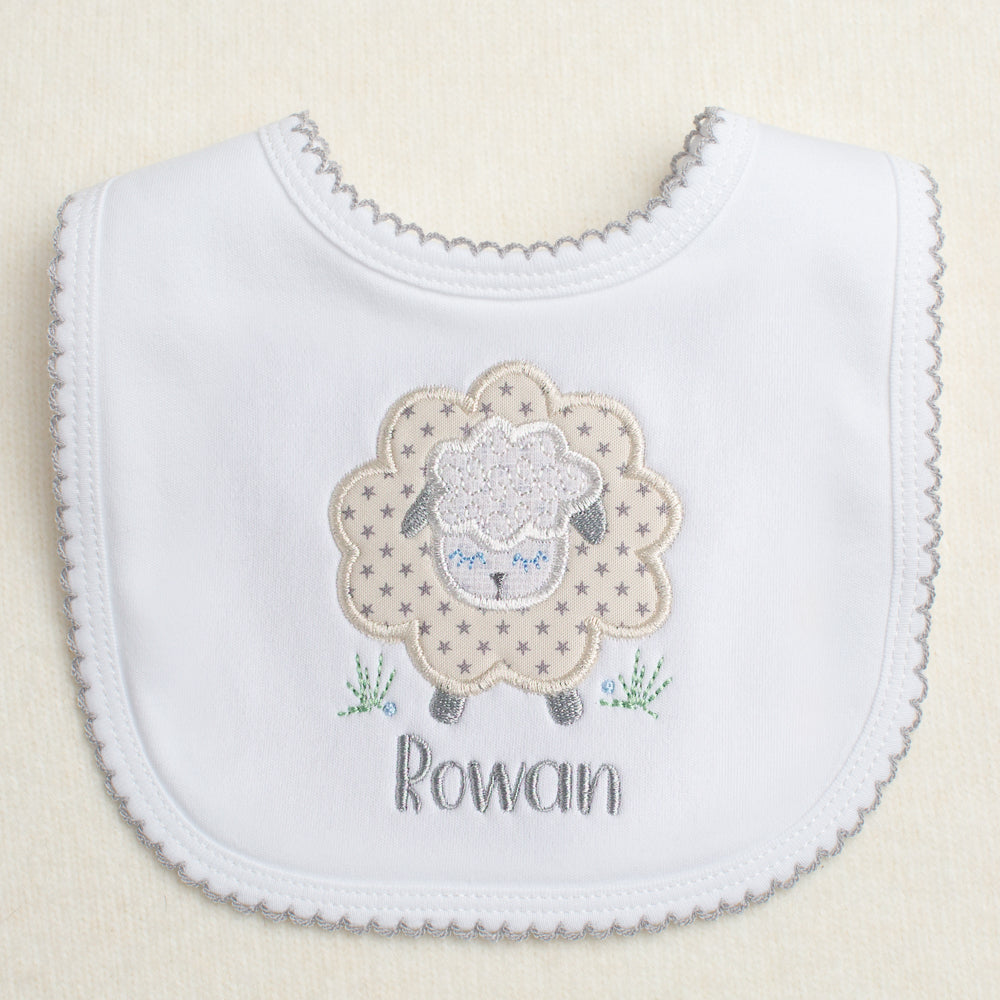 white cotton bib with grey picot trim with a grey star sheep applique and a personalized embroidered name
