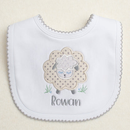 white cotton bib with grey picot trim with a grey star sheep applique and a personalized embroidered name