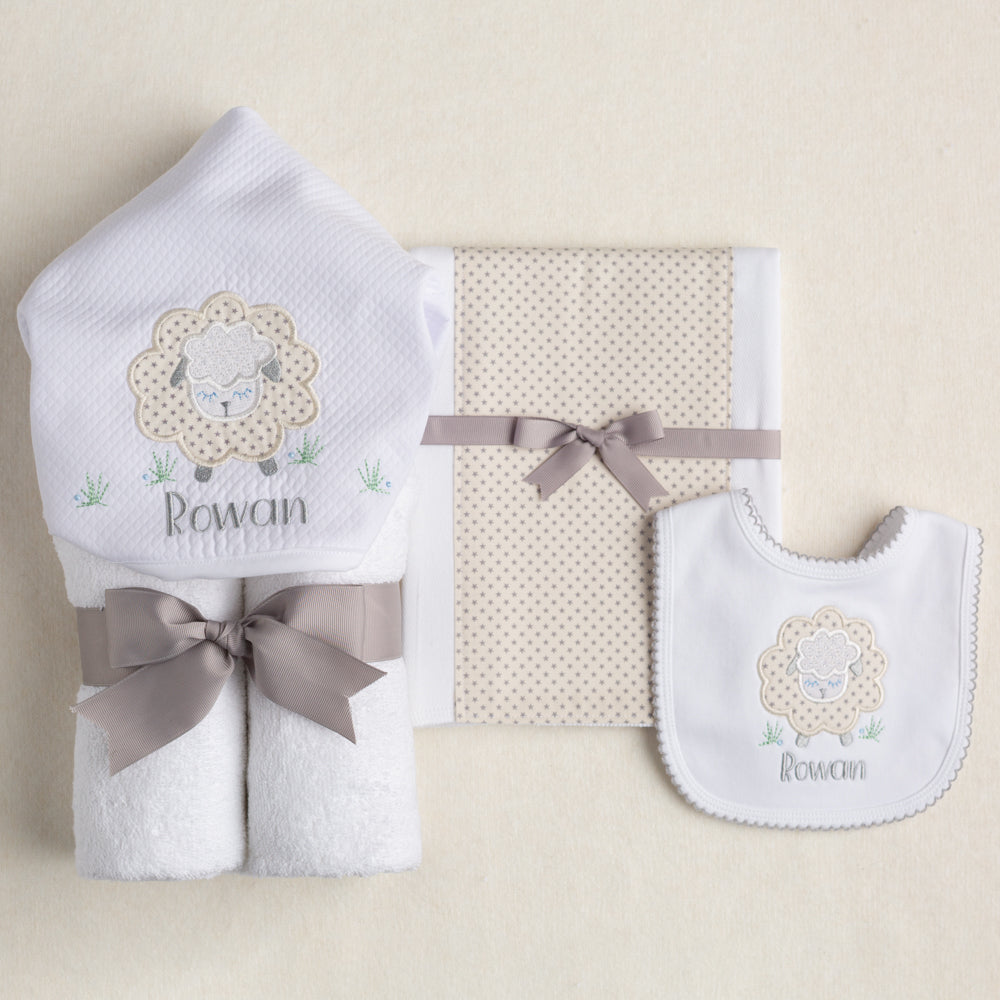 3 piece gender neutral gift set featuring a hooded towel, burp pad and bib the grey and cream tones with  sheep motif