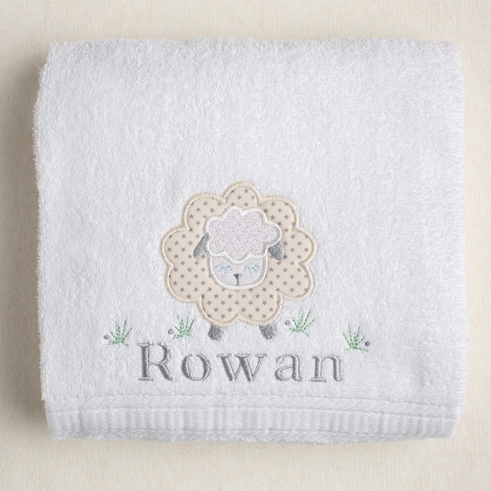 white cotton bath towel with grey star sheep appliqued on it with a personalized embroidered name