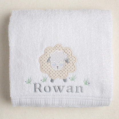 white cotton bath towel with grey star sheep appliqued on it with a personalized embroidered name