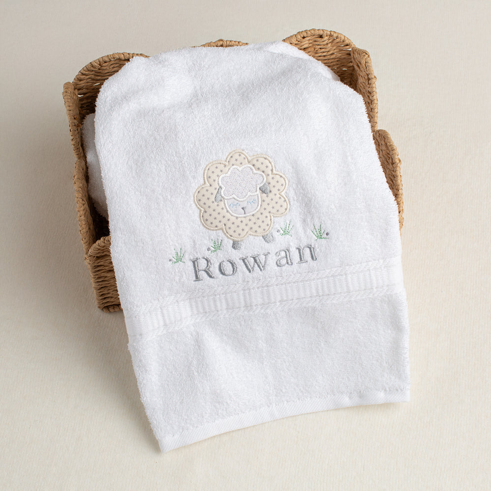 Appliqued grey star sheep on a white, plush cotton bath towel with a personalized embroidered name.
