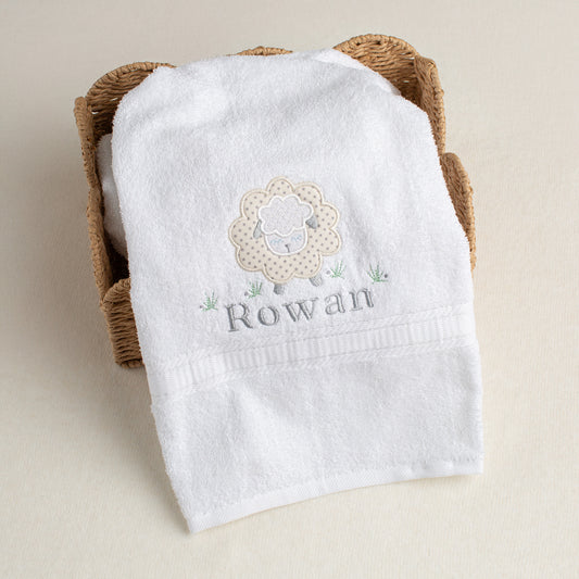 Appliqued grey star sheep on a white, plush cotton bath towel with a personalized embroidered name.
