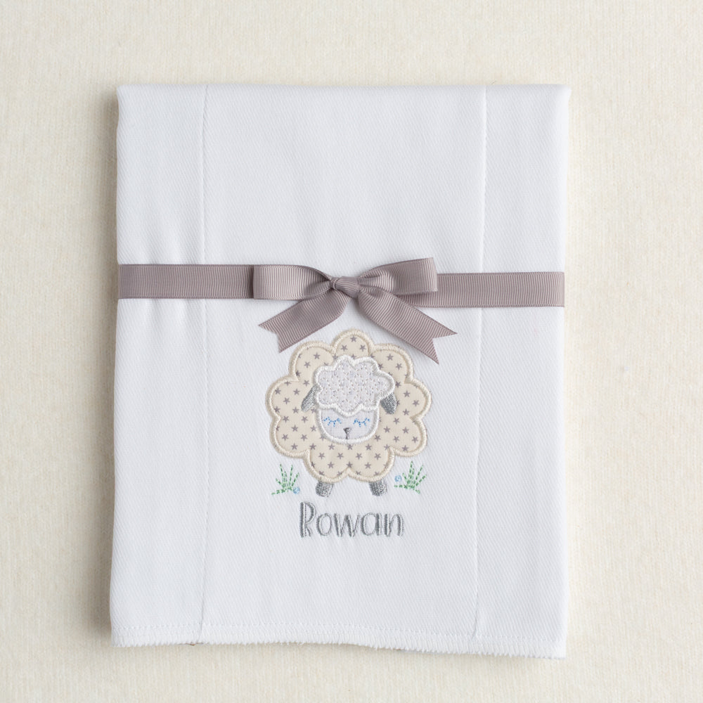 white burp pad made from a 100% cotton diaper with a gender neutral grey star sheep applique with a personalized embroidered name