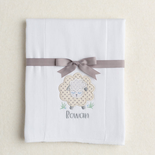 white burp pad made from a 100% cotton diaper with a gender neutral grey star sheep applique with a personalized embroidered name