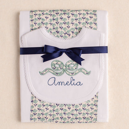 2 piece gift set with a bib with an appliqued bow and a personalized name paired with a burp pad with a Liberty of London fabric panel.