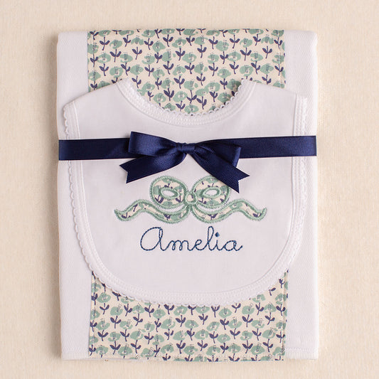 2 piece gift set with a bib with an appliqued bow and a personalized name paired with a burp pad with a Liberty of London fabric panel.