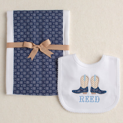 Baby 2 piece gift set with a fabric burp pad and a white bib with a cowboy boot applique and a name embroidered in a western fishtail font.
