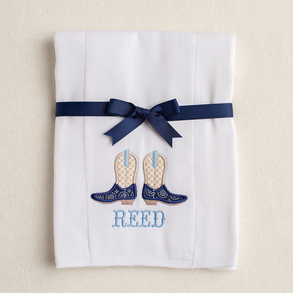 Detail of the cowboy boots applique and personalized embroidered name on the cloth diaper burp pad.  Picture shows how the burp pad is folded and tied with a grosgrain ribbon for gift giving.