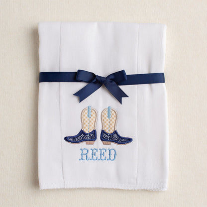 Detail of the cowboy boots applique and personalized embroidered name on the cloth diaper burp pad.  Picture shows how the burp pad is folded and tied with a grosgrain ribbon for gift giving.