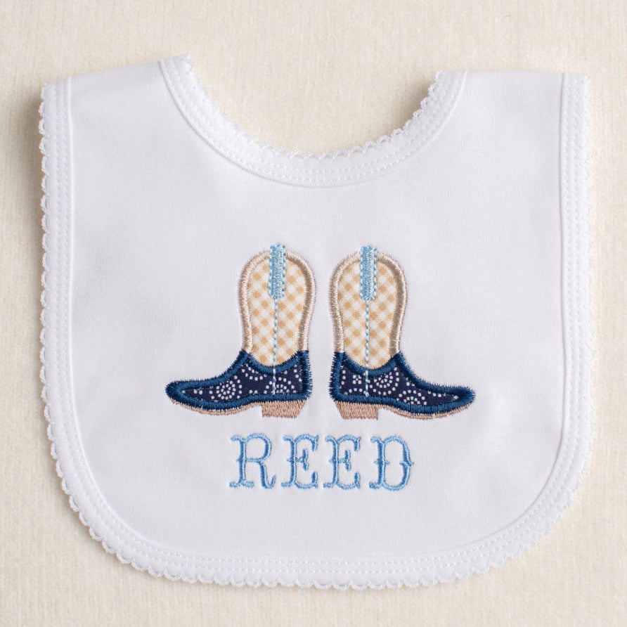 White bib with picot edge personalized with embroidered cowboy boots and a custom name on the bib. Personalized baby gift