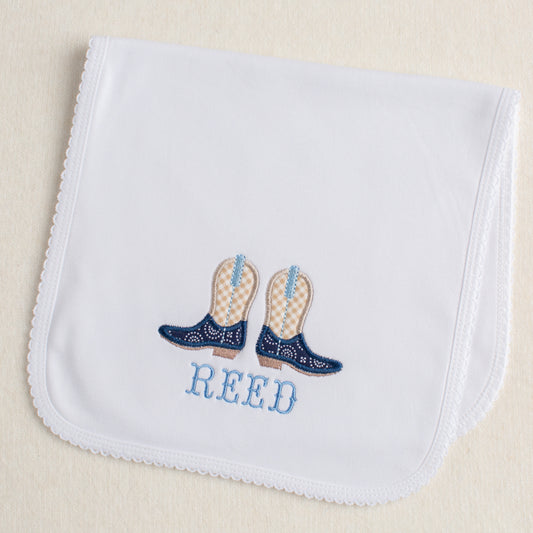Picot trimmed burp pad with a western theme cowboy boot applique with a name embroidered beneath the boots.