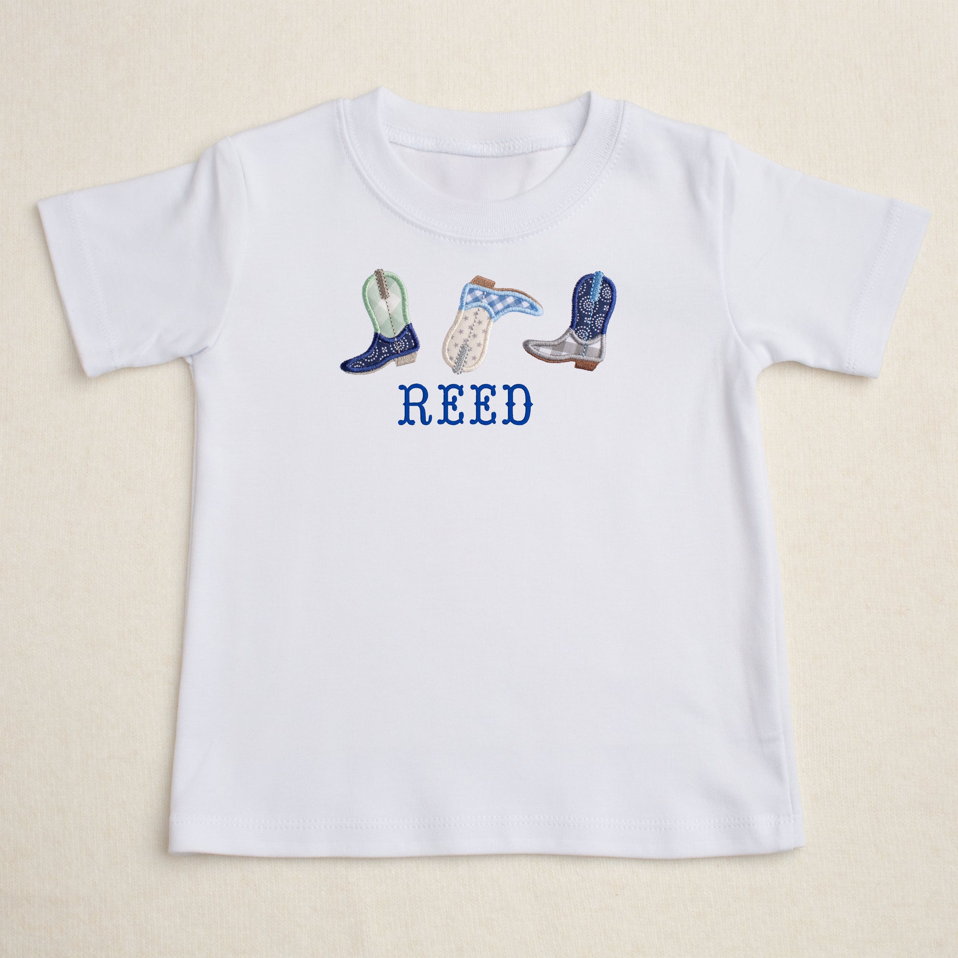 White t=shirt with appliqued cowboy boots and a personalized embroidered name