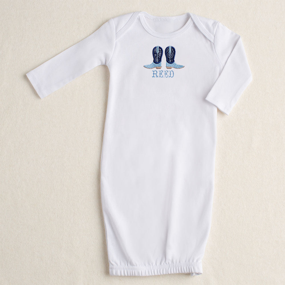 white baby gown with Deacon Lane signature applique in navy applique cowboy boots with a custom personalized name embroidered in a western theme font