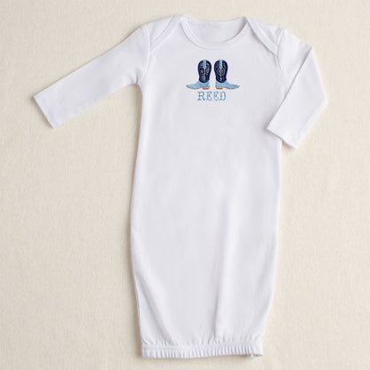 white baby gown with Deacon Lane signature applique in navy applique cowboy boots with a custom personalized name embroidered in a western theme font