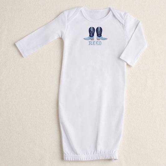 white baby gown with Deacon Lane signature applique in navy applique cowboy boots with a custom personalized name embroidered in a western theme font