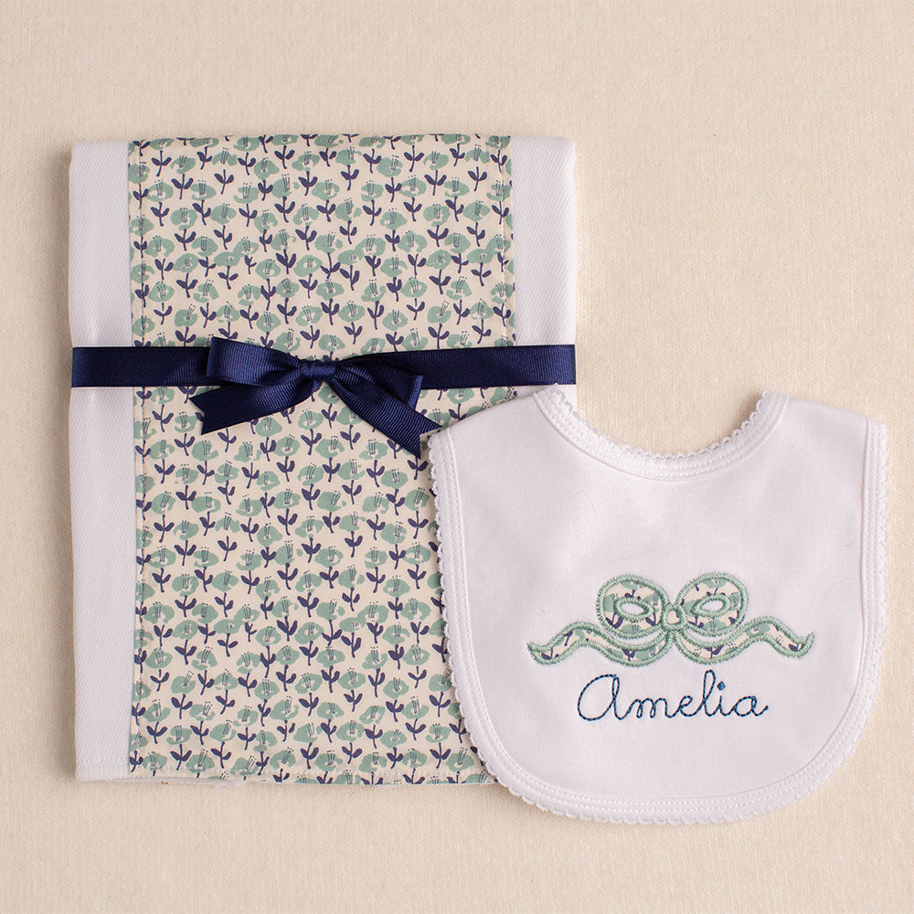 close up of Deacon Lane's burp pad and bib set with an appliqued navy floral bow