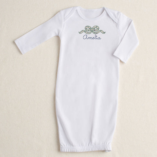 white baby gown with navy floral applique bow and personalize name