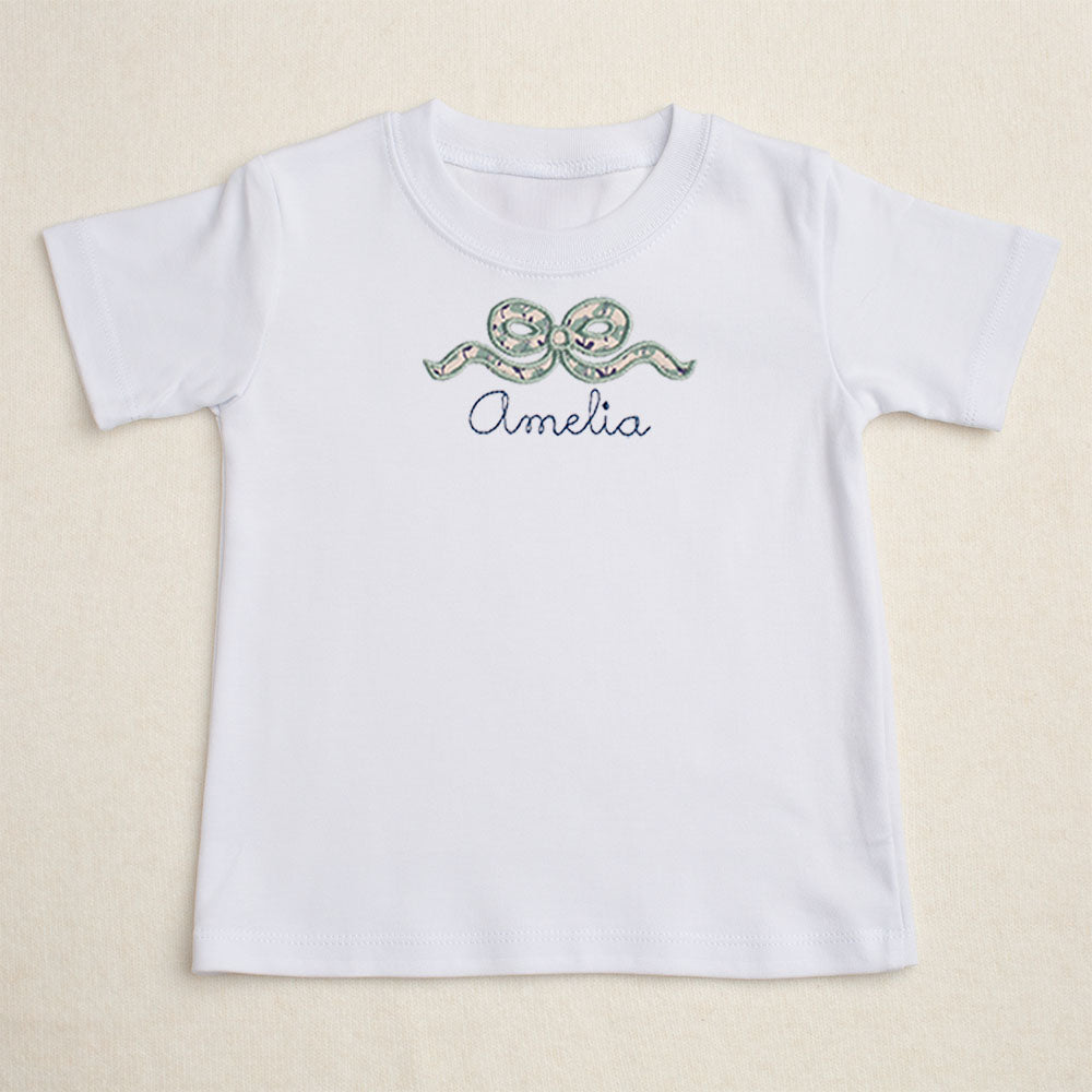 Girls white t-shirt with Deacon Lane's applique bow design in a navy and seafoam/sage floral.