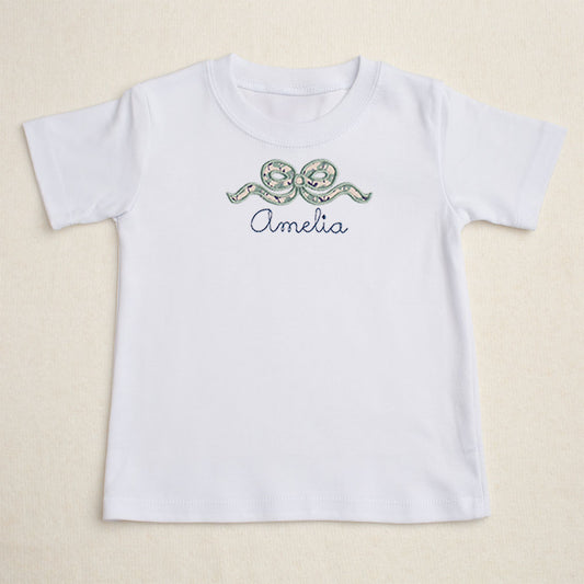 Girls white t-shirt with Deacon Lane's applique bow design in a navy and seafoam/sage floral.