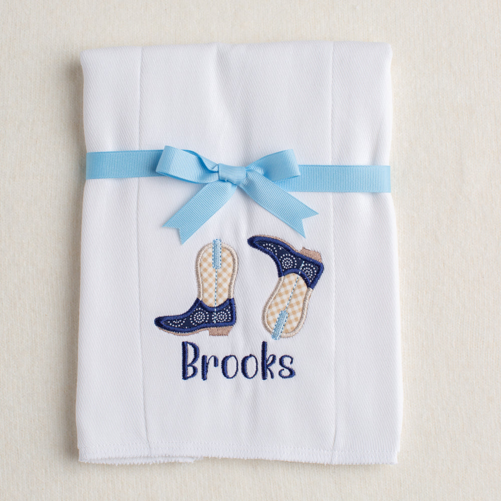 White cotton burp pad with custom appliqued navy and khaki cowboy boots with personalized embroidered name for perfect gift giving.
