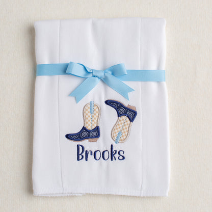 White cotton burp pad with custom appliqued navy and khaki cowboy boots with personalized embroidered name for perfect gift giving.

