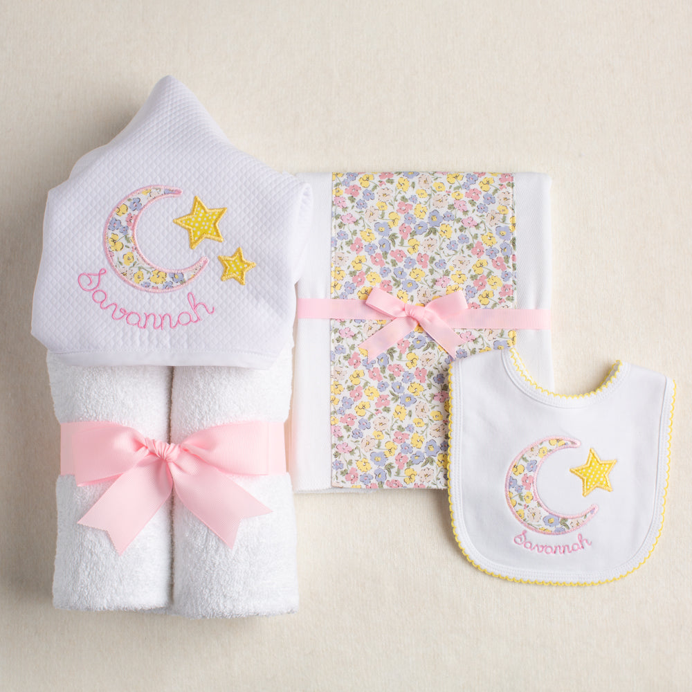Baby gift set with hooded towel, fabric burp pad and bib all with a pink Liberty like floral motif for personalized boutique baby gift giving