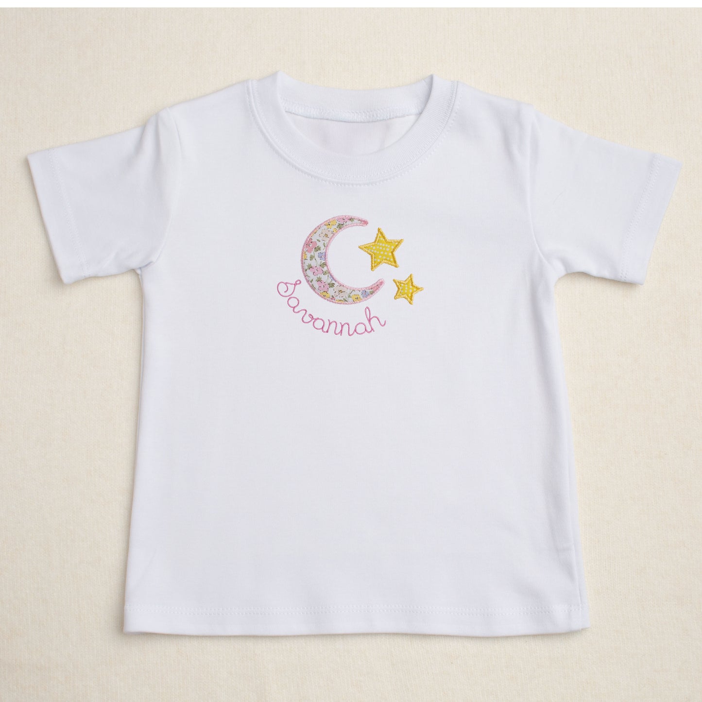 Premium white t-shirt with a darling handmade applique out of a fabric reminiscent of a Liberty of London floral print in a moon and star motif.
