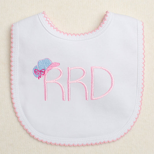 white bib with monogram and an embroidered cowgirl hat